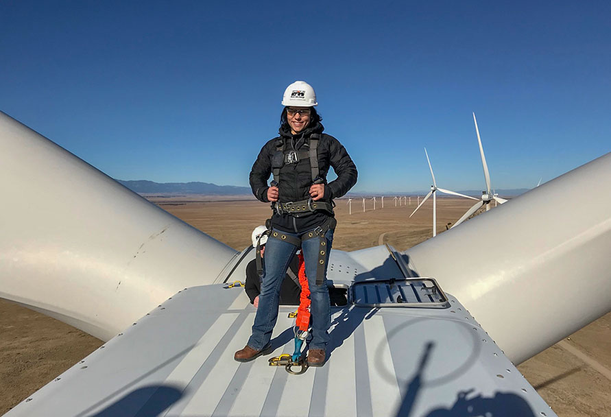 woman standing on a wind turbine