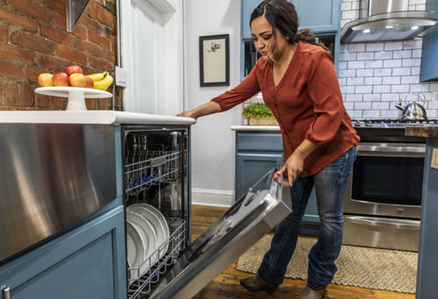 Woman closing dishwasher