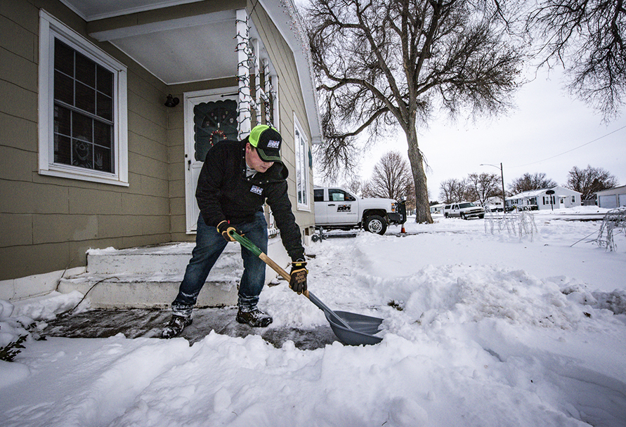 Shoveling snow in front of a house