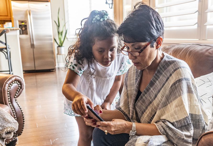 Grandma and granddaughter using mobile phone