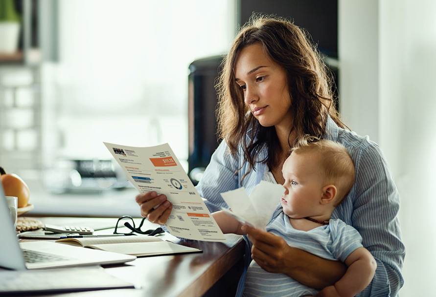 Woman with baby reviewing energy bill