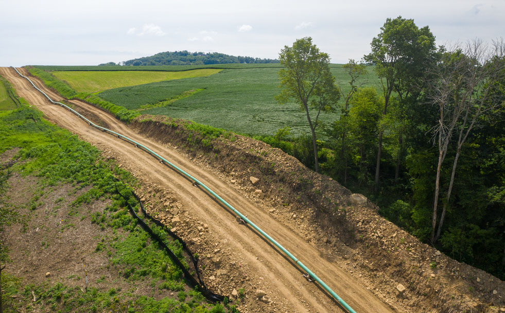 Natural gas pipeline laid out on a gravel road.