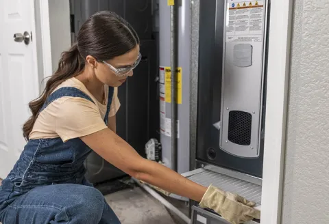 Woman replacing a furnace filter